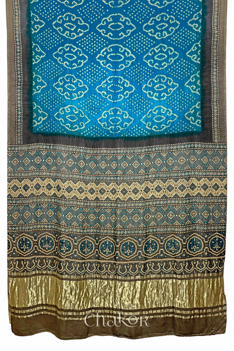 Full view of Peacock Blue Bandhani Saree with Brown Ajrakh printed border and pallu in pure gaji silk with traditional bandhej tie-dye, handcrafted in Kutch. 