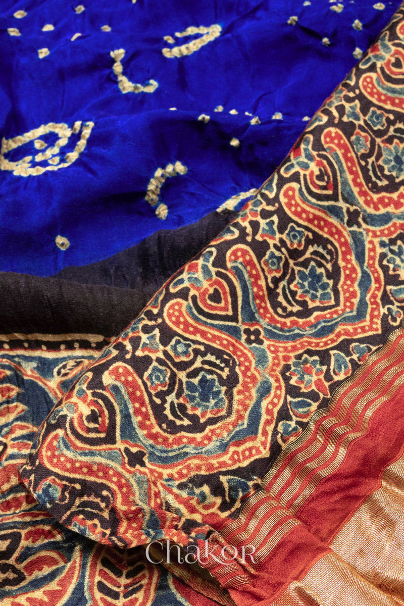 Close up of Blue Red Bandhani Ajrakh Silk Saree with intricate bandhani motifs and a zari stripe pallu, hand block printed using natural dyes on luxurious gaji silk fabric.