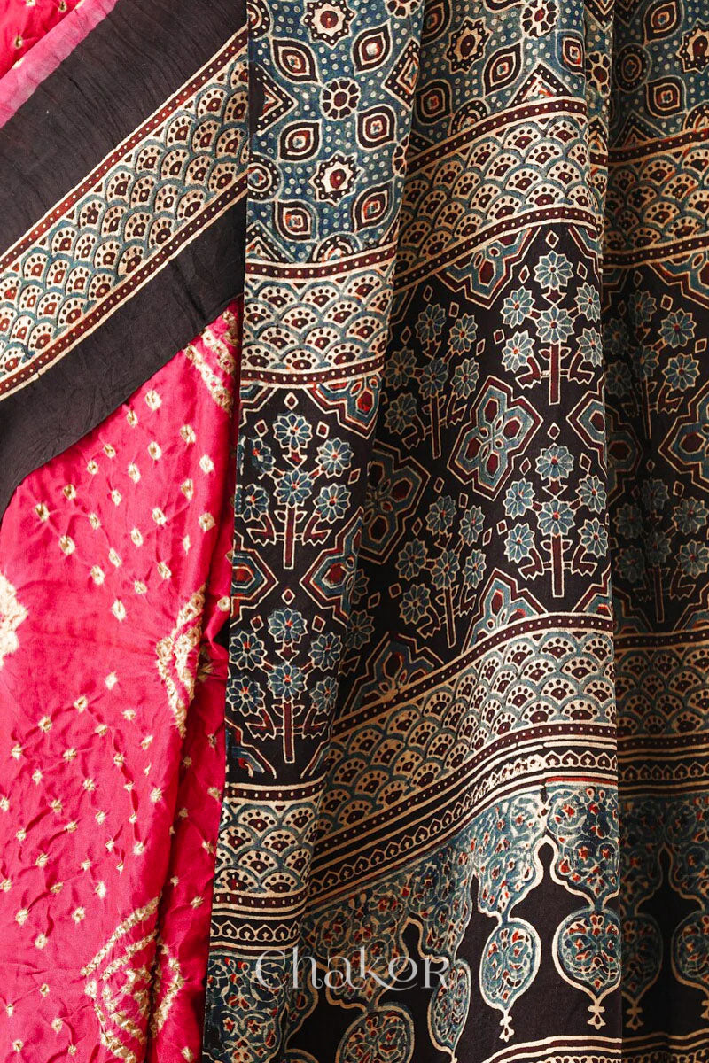 Close up of Coral Pink Bandhani Saree with Black Ajrakh printed border and pallu in pure gaji silk with traditional bandhej tie-dye, handcrafted in Kutch. 