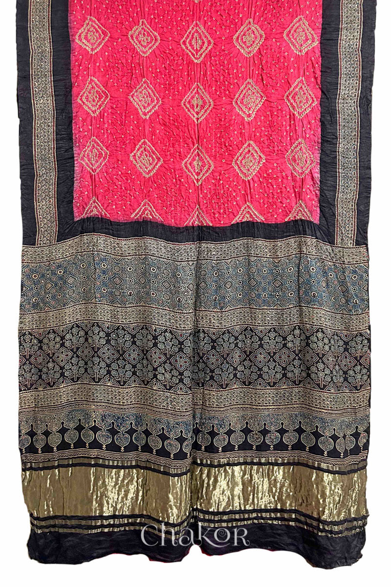 Full view of Coral Pink Bandhani Saree with Black Ajrakh printed border and pallu in pure gaji silk with traditional bandhej tie-dye, handcrafted in Kutch. 