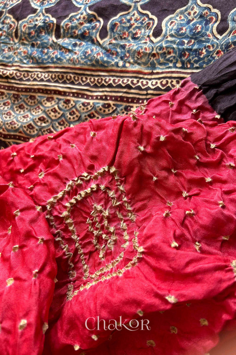 Close up of Coral Pink Bandhani Saree with Black Ajrakh printed border and pallu in pure gaji silk with traditional bandhej tie-dye, handcrafted in Kutch. 
