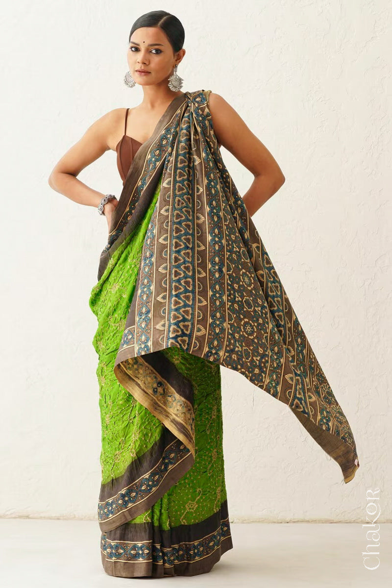 Woman wearing Parrot green Bandhani Saree with Brown Ajrakh printed border and pallu in pure gaji silk with traditional bandhej tie-dye, handcrafted in Kutch. 