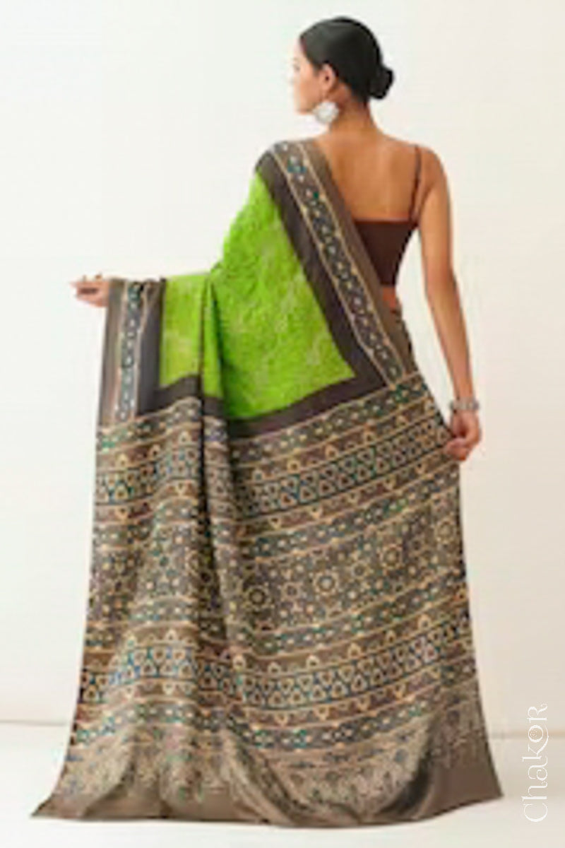 Woman wearing Parrot green Bandhani Saree with Brown Ajrakh printed border and pallu in pure gaji silk with traditional bandhej tie-dye, handcrafted in Kutch. 