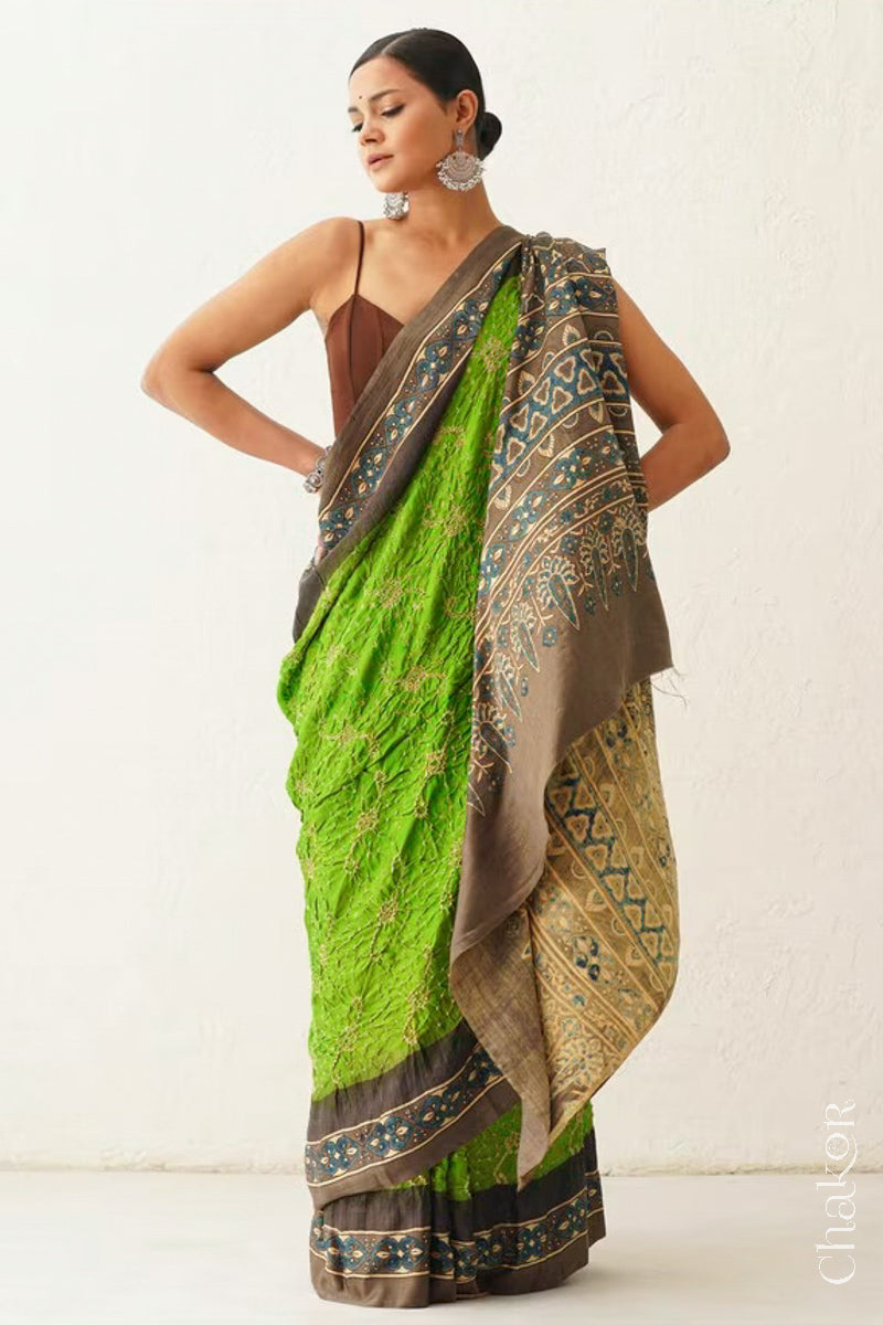 Woman wearing Parrot green Bandhani Saree with Brown Ajrakh printed border and pallu in pure gaji silk with traditional bandhej tie-dye, handcrafted in Kutch. 