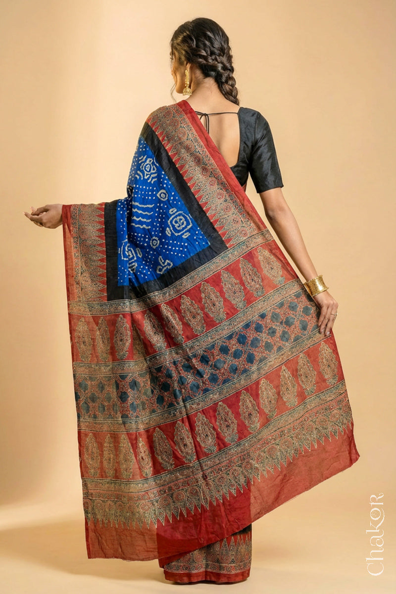 Woman wearing Blue Bandhani Saree with Natural Red Ajrakh printed border and pallu in pure gaji silk with traditional bandhej tie-dye, handcrafted in Kutch. 
