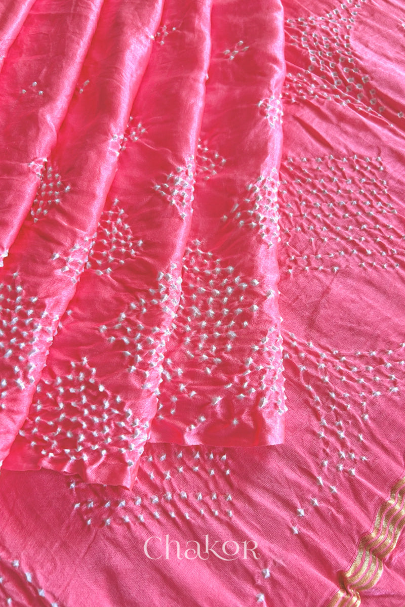 Close up of Handcrafted Coral Pink Bandhani Gaji Silk Saree with rai bandhej patterns and tissue pallu.