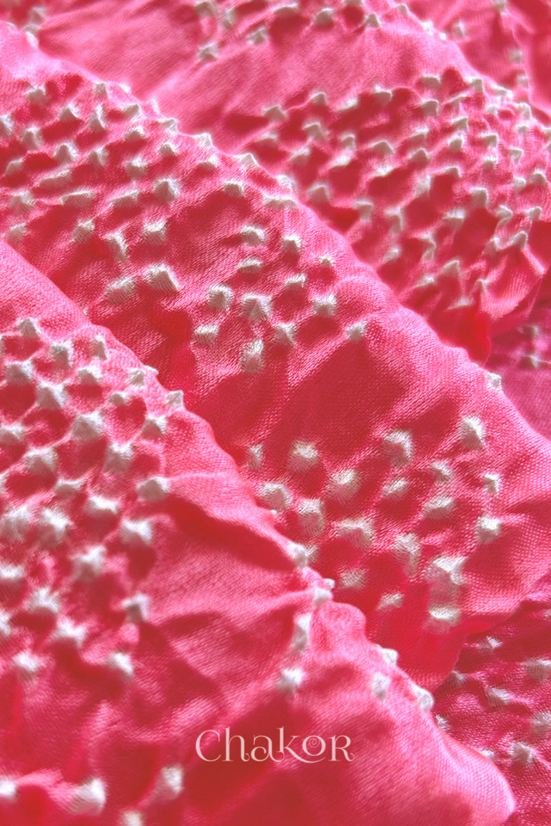 Close up of Handcrafted Coral Pink Bandhani Gaji Silk Saree with rai bandhej patterns and tissue pallu.