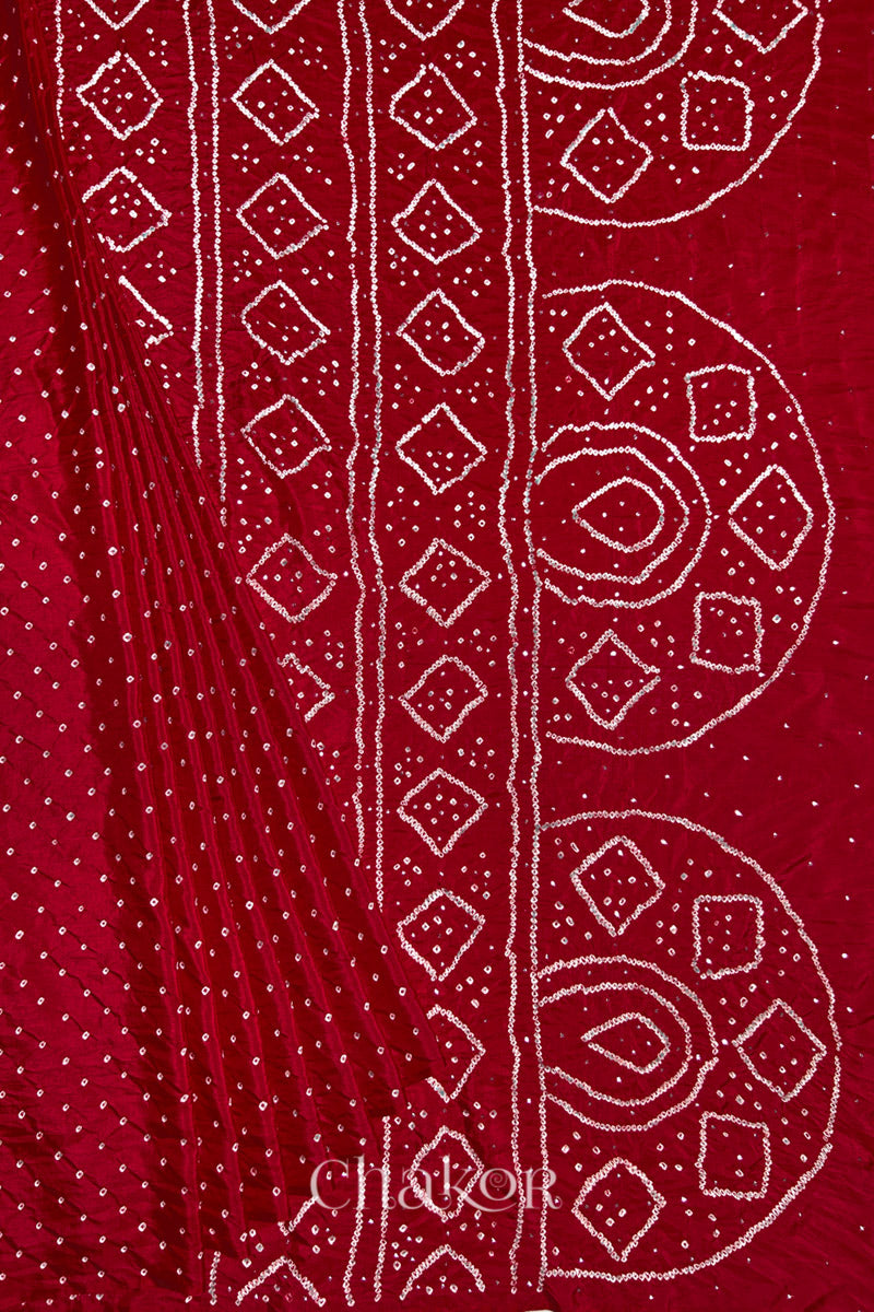 Pleated view of Red Bandhani Mulberry Silk Saree, handcrafted in rai bandhej patterns with mukaish embroidery.