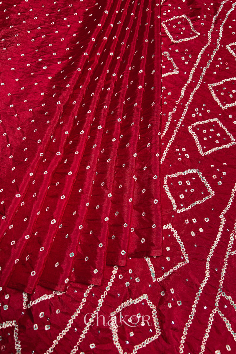 Pleated view of Red Bandhani Mulberry Silk Saree, handcrafted in rai bandhej patterns with mukaish embroidery.