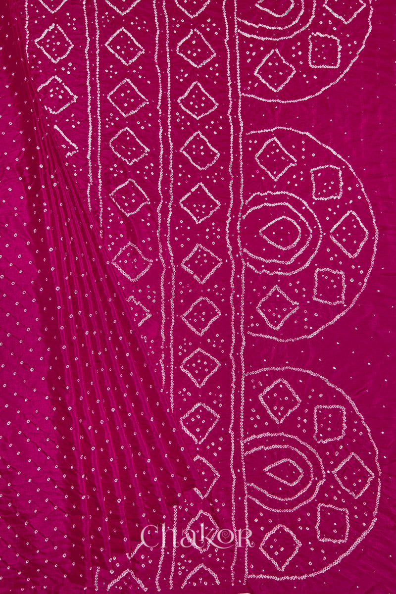 Pleated view of Rani pink Bandhani Mulberry Silk Saree, handcrafted in rai bandhej patterns with mukaish embroidery.