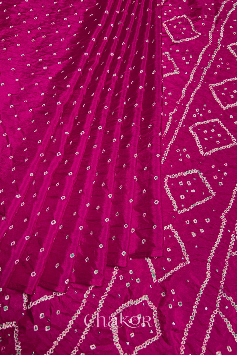 Pleated view of Rani pink Bandhani Mulberry Silk Saree, handcrafted in rai bandhej patterns with mukaish embroidery.