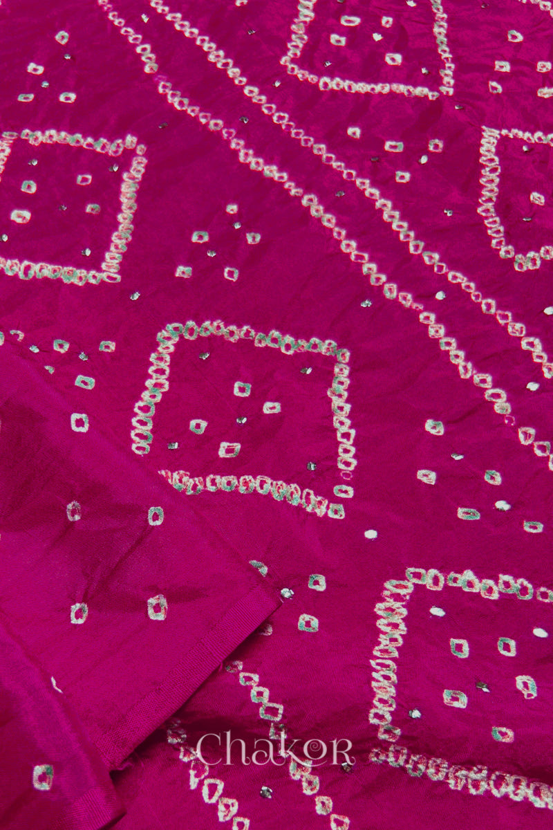 Close up of Rani pink Bandhani Mulberry Silk Saree, handcrafted in rai bandhej patterns with mukaish embroidery.