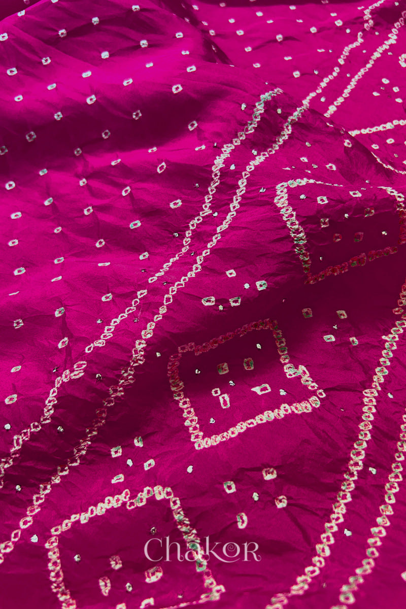 Close up of Rani pink Bandhani Mulberry Silk Saree, handcrafted in rai bandhej patterns with mukaish embroidery.