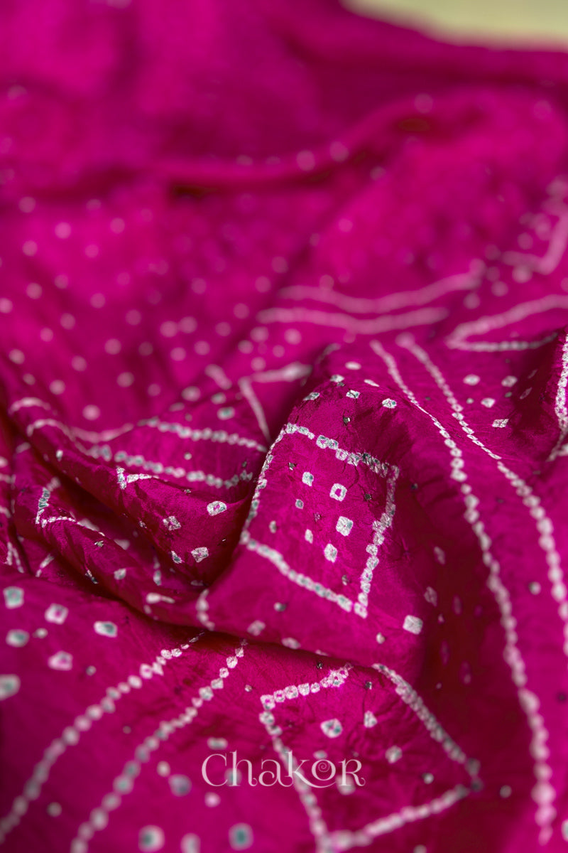 Close up of Rani pink Bandhani Mulberry Silk Saree, handcrafted in rai bandhej patterns with mukaish embroidery.