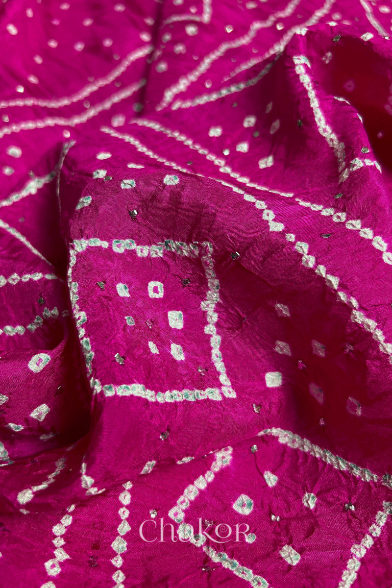 Close up of Rani pink Bandhani Mulberry Silk Saree, handcrafted in rai bandhej patterns with mukaish embroidery.