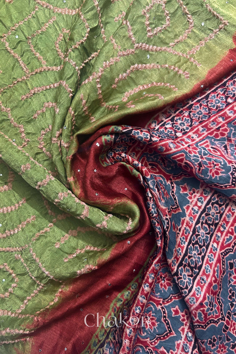 Draped detail view of leaf green Bandhani gaji silk dupatta showing body and Ajrakh pallu together with hand embroidery mukaish details.