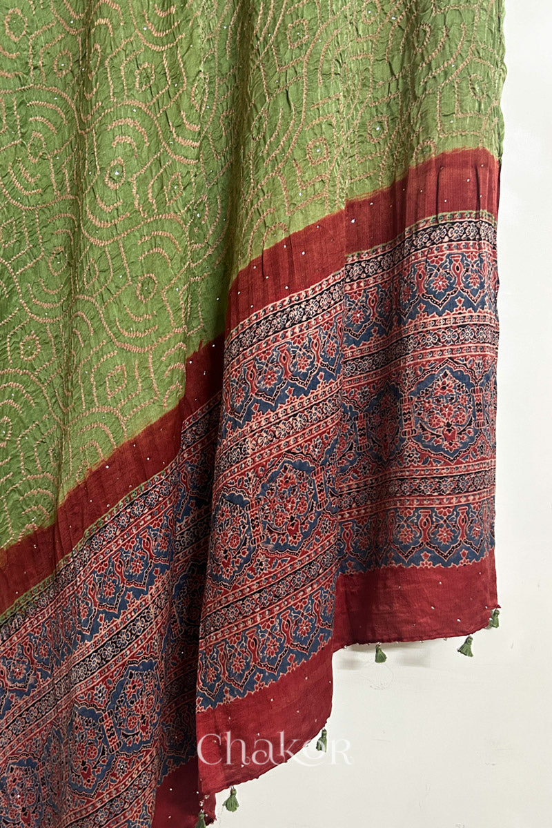 Hanging view of leaf green Bandhani gaji silk dupatta highlighting Ajrakh pallu and border.