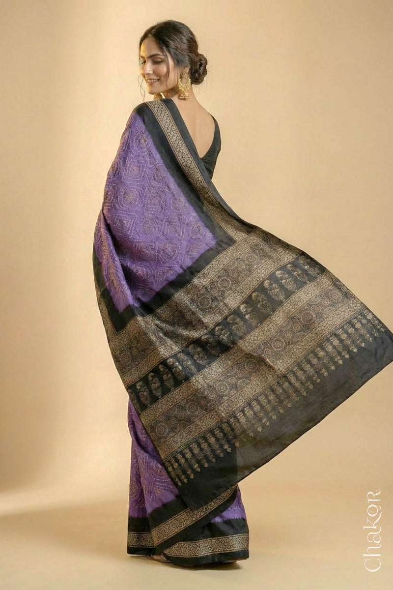 Woman wearing Mauve Bandhani Saree with Natural Black Ajrakh printed border and pallu in pure gaji silk with traditional bandhej tie-dye, handcrafted in Kutch. 