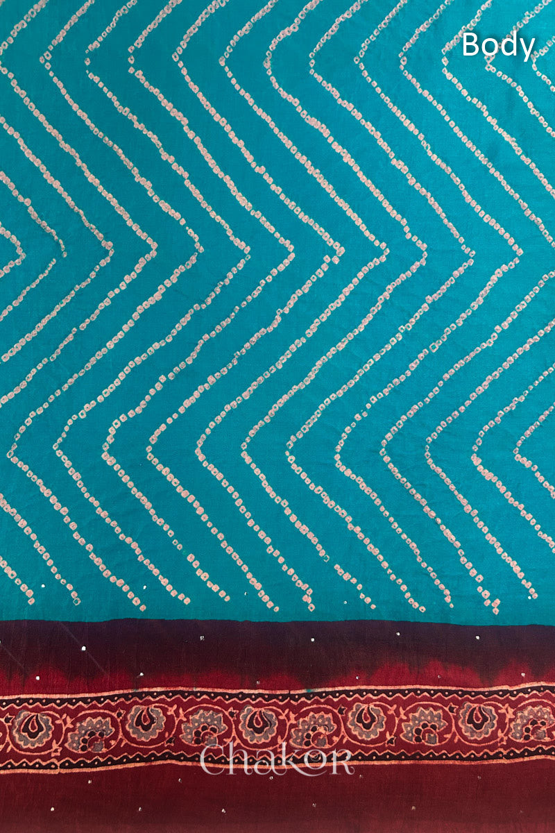 Close up of Peacock Blue Bandhani Saree with Natural Red Ajrakh printed border and pallu in pure gaji silk with traditional bandhej tie-dye & mukaish embroidery, handcrafted in Kutch. 