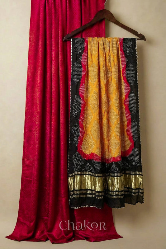 Red Unstitched Mashru Silk Kurta Set Material paired with Handcrafted Mustard Bandhani Gaji silk dupatta with black and red borders.