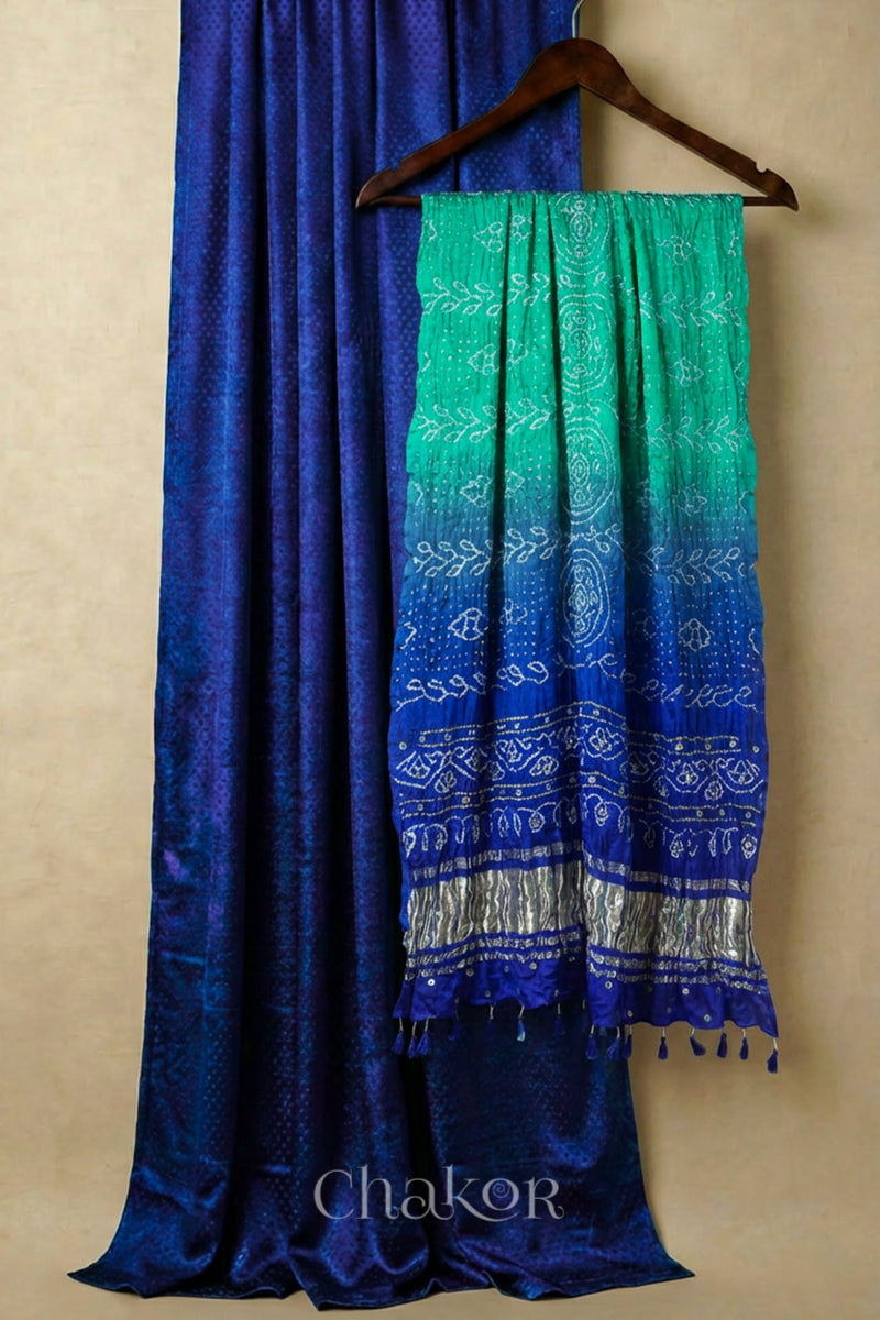 Royal Blue mashru silk kurta set fabric paired with sea green blue ombre bandhani gaji silk dupatta featuring golden zari pallu & embellished with mirrors & edged with tassels.