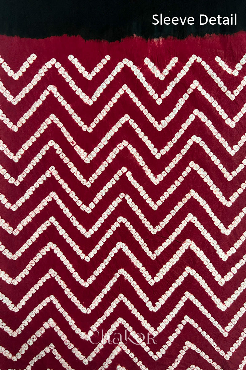 Close-up of  black bandhani fabric featuring chevron tie-dye design, with Chakor brand logo. Text reads sleeve details.