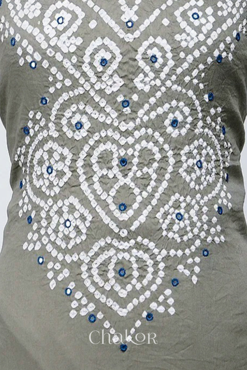 Close-up of bandhani yoke kurta fabric featuring floral & spiral tie-dye design and indigo blue mirror embroidery, with Chakor brand logo.
