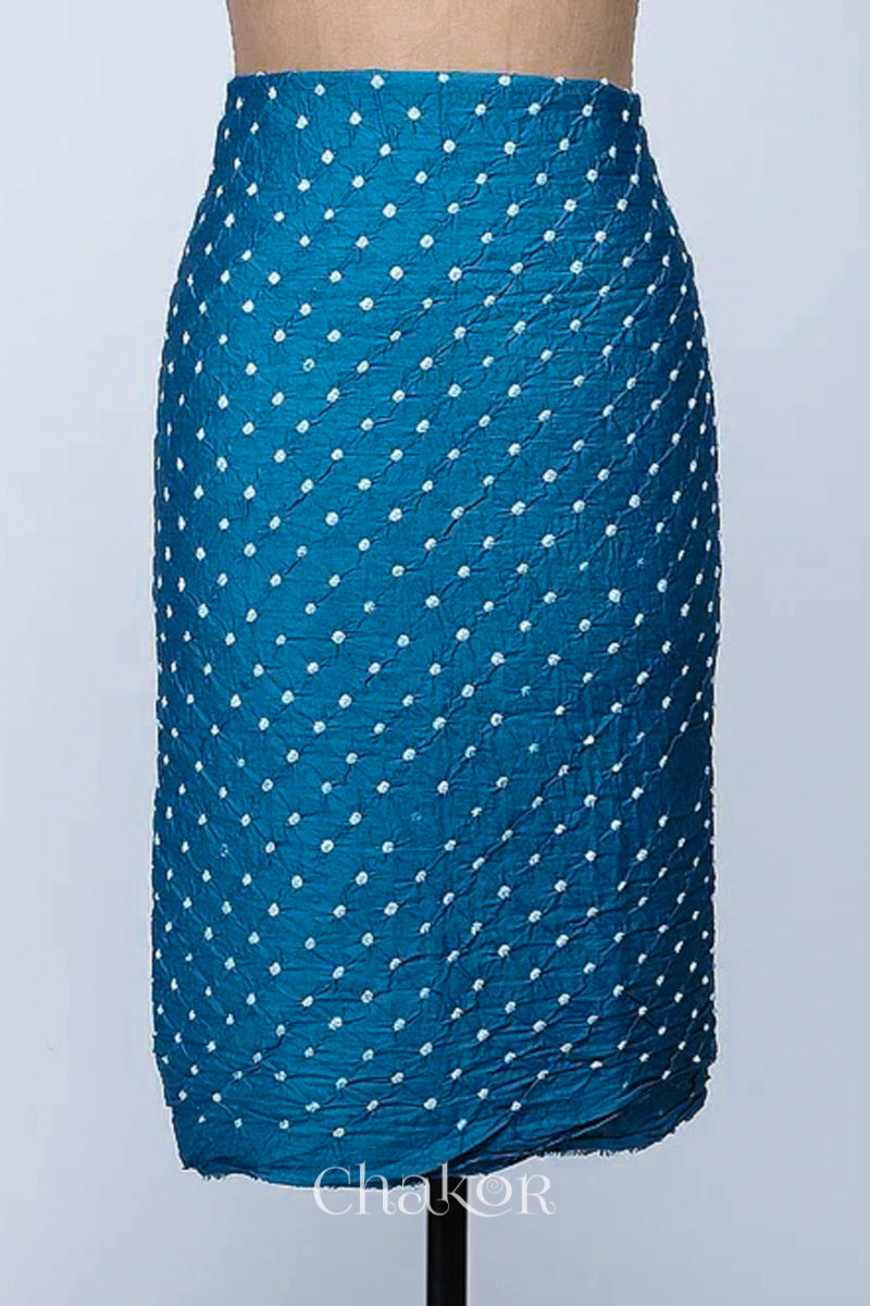 Bottom fabric in indigo blue patterned with simple bandhani tie dye dots, draped neatly on a dress form, with Chakor brand logo.
