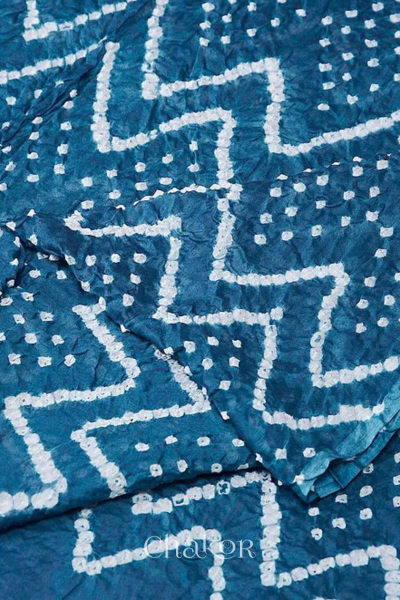 Close up indigo blue cotton mul dupatta detail featuring intricate white zigzag bandhani dot patterns, showcasing traditional design.
