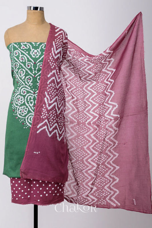 A stylish kurta set fabric featuring a moss green mirror embroidered plum pink top, a bandhani plum pink bottom, and a matching plum pink dupatta draped elegantly. Text reads Chakor.
