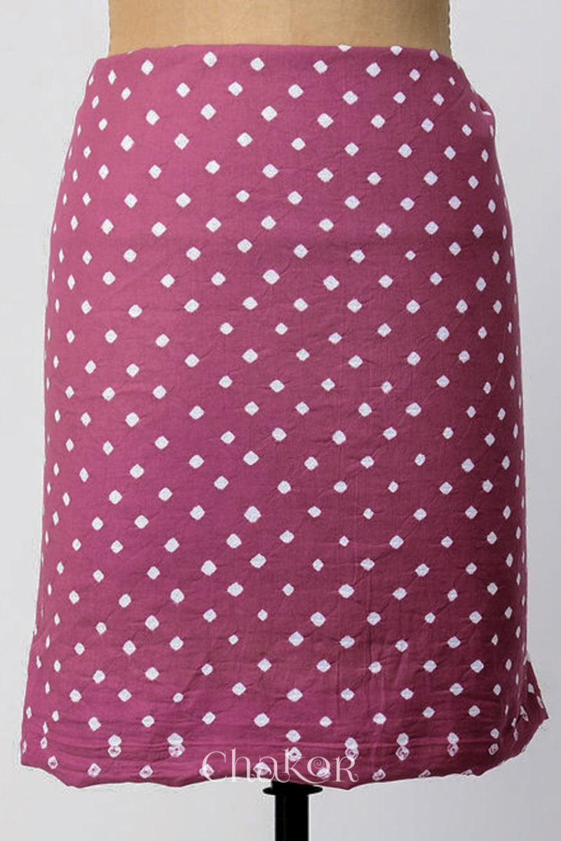 Bottom fabric in plum pink patterned with simple bandhani tie dye dots, draped neatly on a dress form, with Chakor brand logo.
