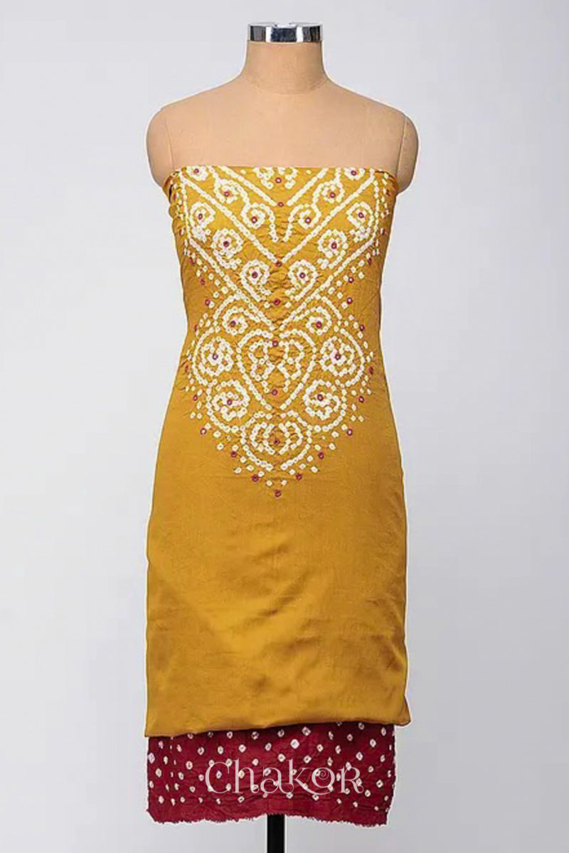 A stylish fabric featuring a mustard mirror embroidered top, a bandhani red bottom. Text reads Chakor.
