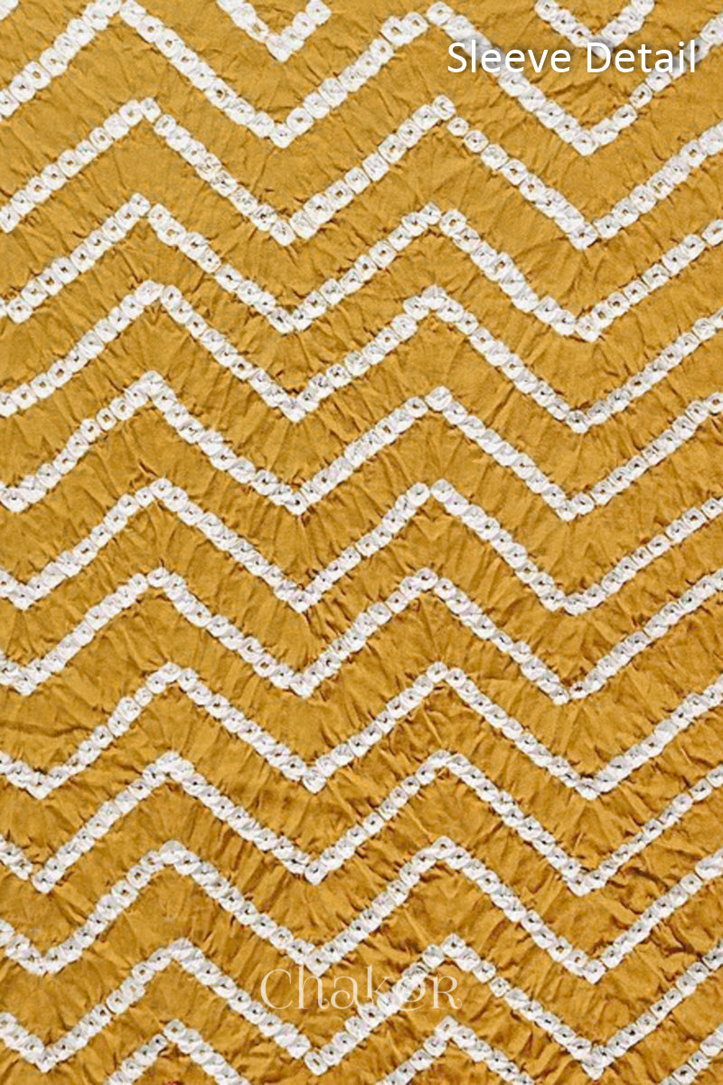 Close-up of bandhani sleeve detail featuring chevron tie-dye design, with Chakor brand logo.
