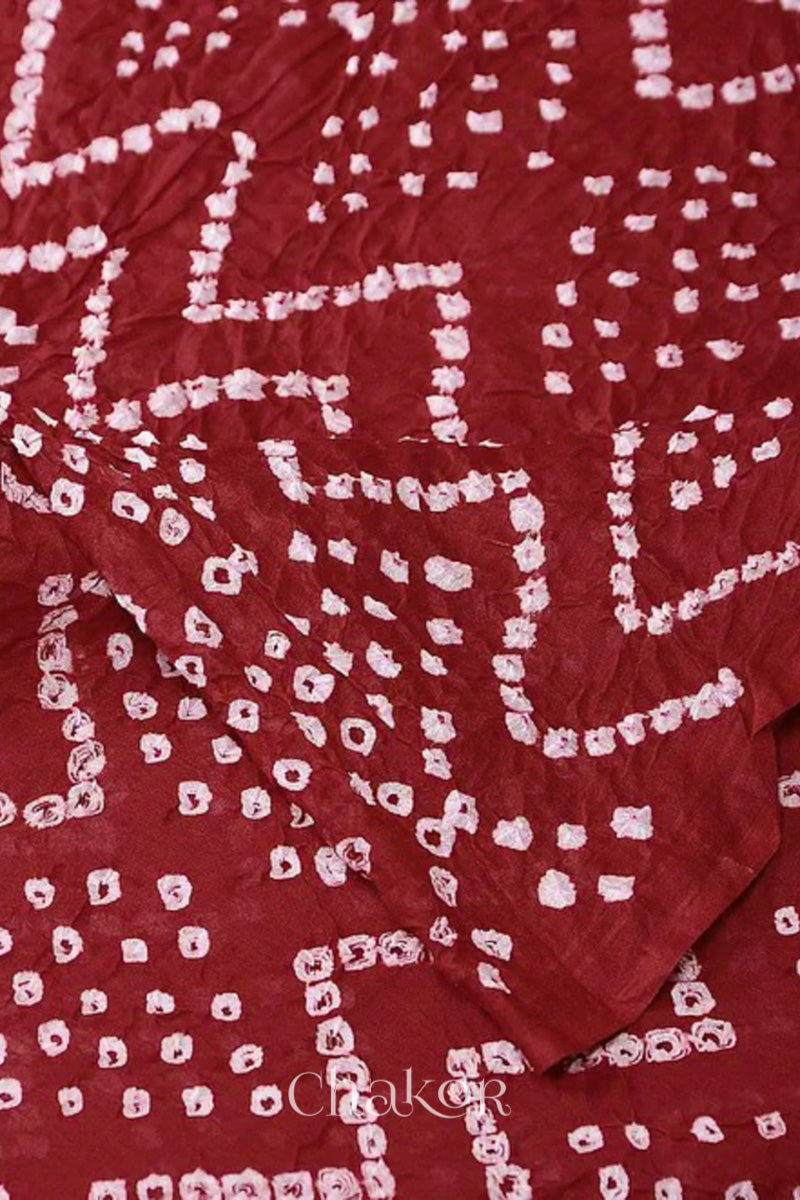 Close up red cotton mul dupatta detail featuring intricate white zigzag bandhani dot patterns, showcasing traditional design.
