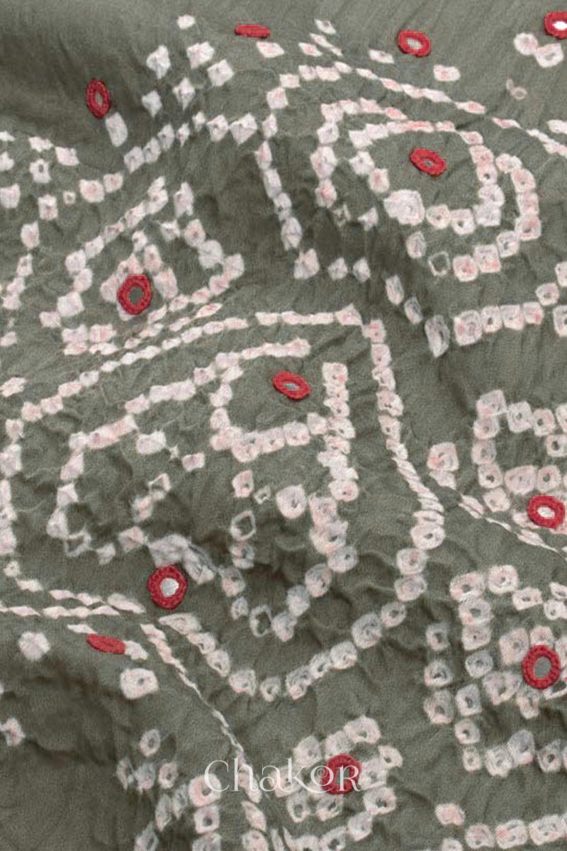 Close-up of bandhani yoke kurta fabric featuring floral & spiral tie-dye design and red mirror embroidery, with Chakor brand logo.

