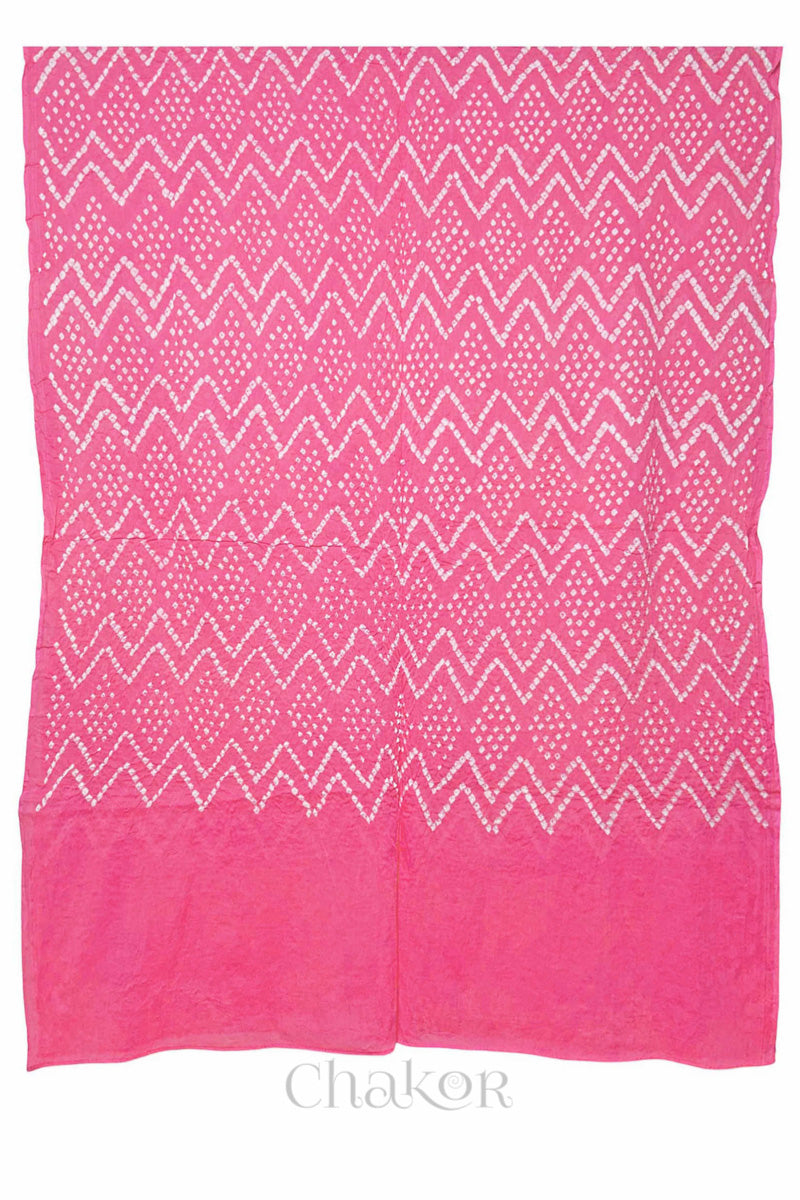 A pink cotton mul dupatta featuring intricate white zigzag bandhani dot patterns, showcasing traditional design.

