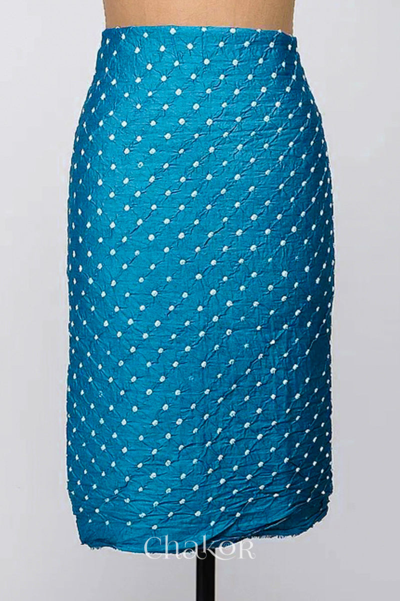 Bottom fabric in turquoise blue patterned with simple bandhani tie dye dots, draped neatly on a dress form, with Chakor brand logo.
