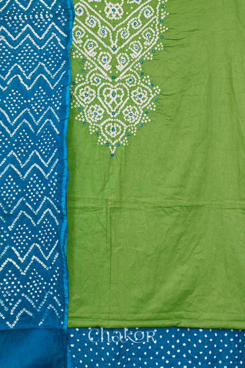 A mehendi green kurta set fabric with intricate white bandhani & mirror embroidery, paired with a turquoise blue bottom & odhani featuring a zigzag design.
