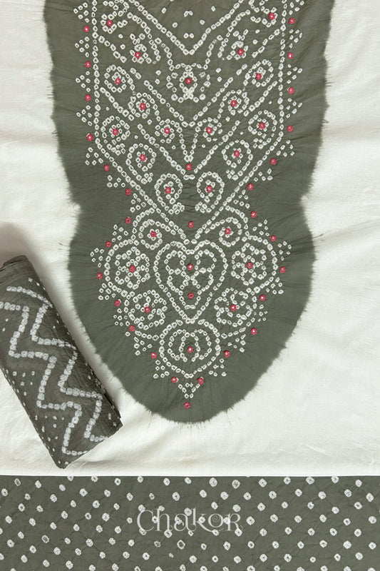 A stylish set fabric featuring a grey mirror embroidered yoke on a white kurta, bandhani grey bottom and dupatta rolled beautifully and placed on the fabric. Text reads Chakor.