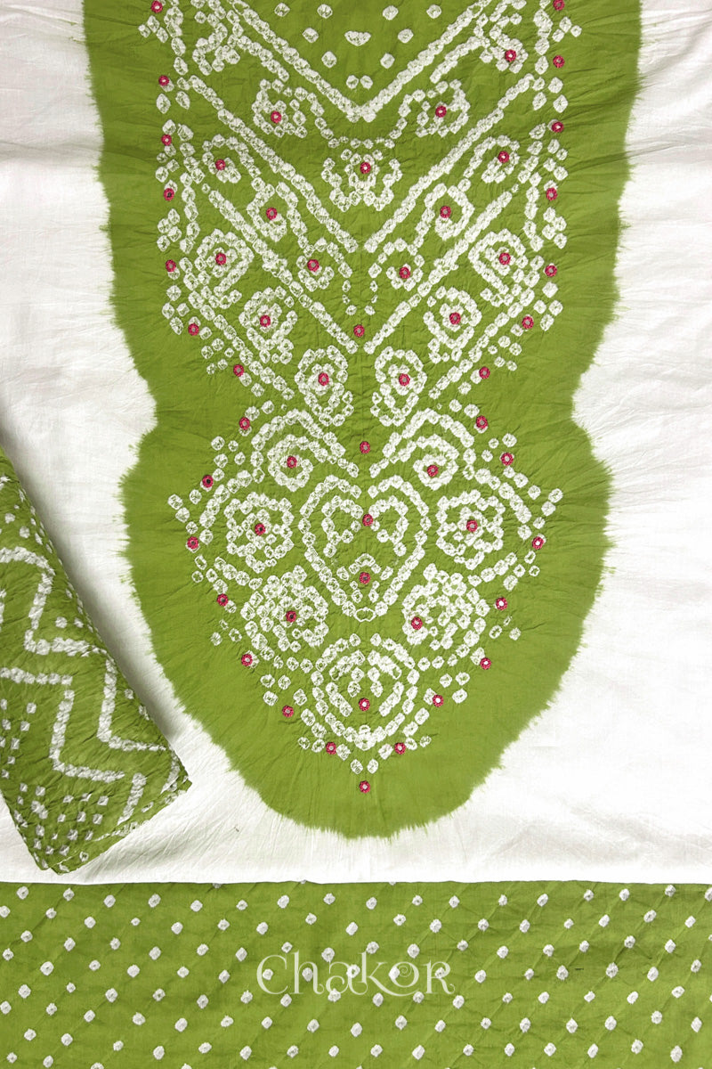 A stylish set fabric featuring a Lime mirror embroidered yoke on a white kurta, bandhani Lime bottom and dupatta rolled beautifully and placed on the fabric. Text reads Chakor.