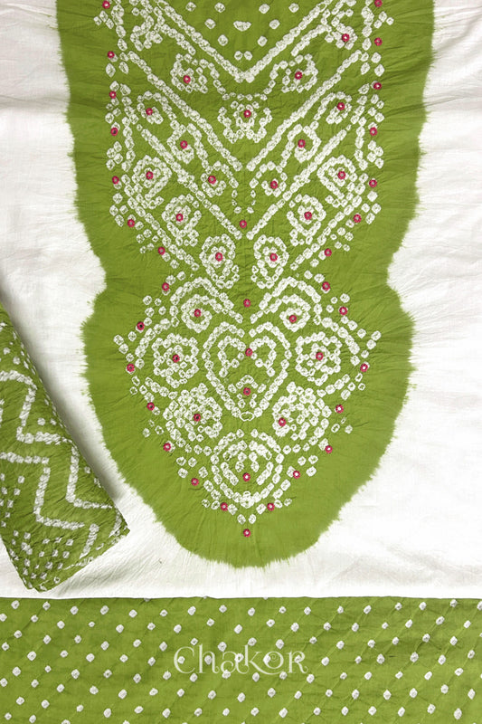 A stylish set fabric featuring a Lime mirror embroidered yoke on a white kurta, bandhani Lime bottom and dupatta rolled beautifully and placed on the fabric. Text reads Chakor.