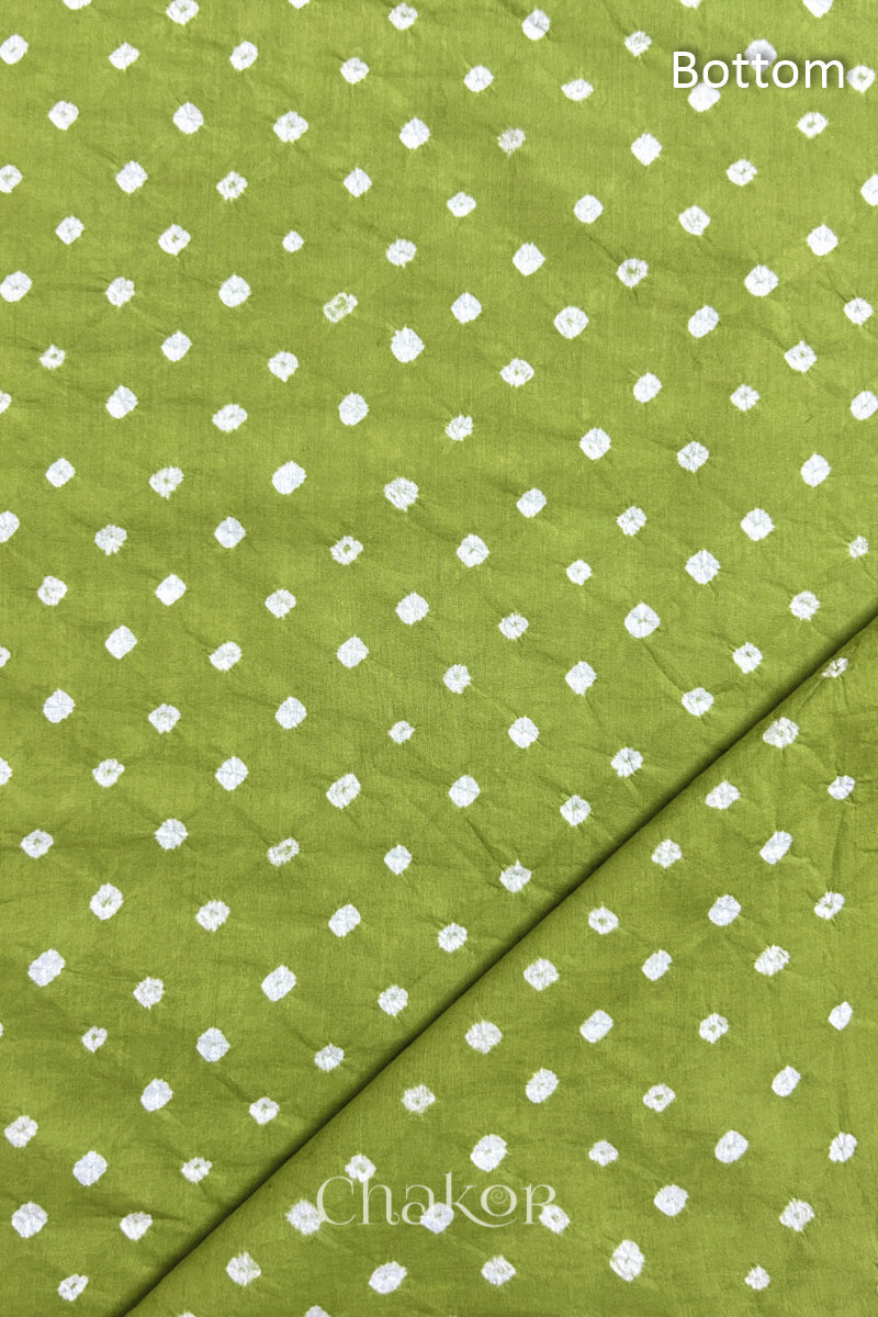 Close up of Bottom fabric in Lime patterned with bandhani tie dye dots, folded at the corner displaying texture and detail.