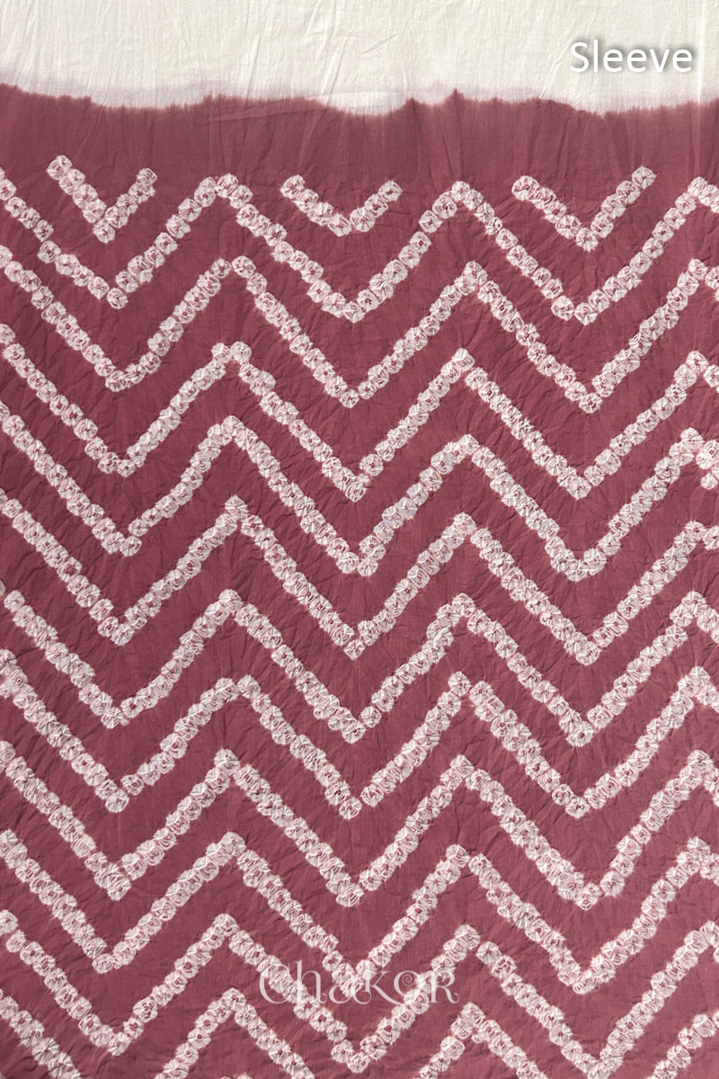 Close-up of soft rose pink bandhani fabric featuring chevron tie-dye design, with Chakor brand logo. Text reads sleeve details.