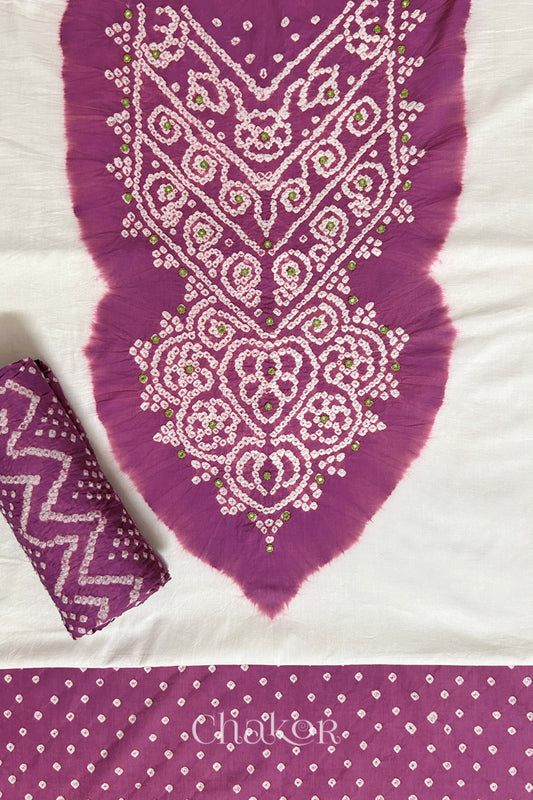 A stylish set fabric featuring a deep violet mirror embroidered yoke on a white kurta, bandhani deep violet bottom and dupatta rolled beautifully and placed on the fabric. Text reads Chakor.