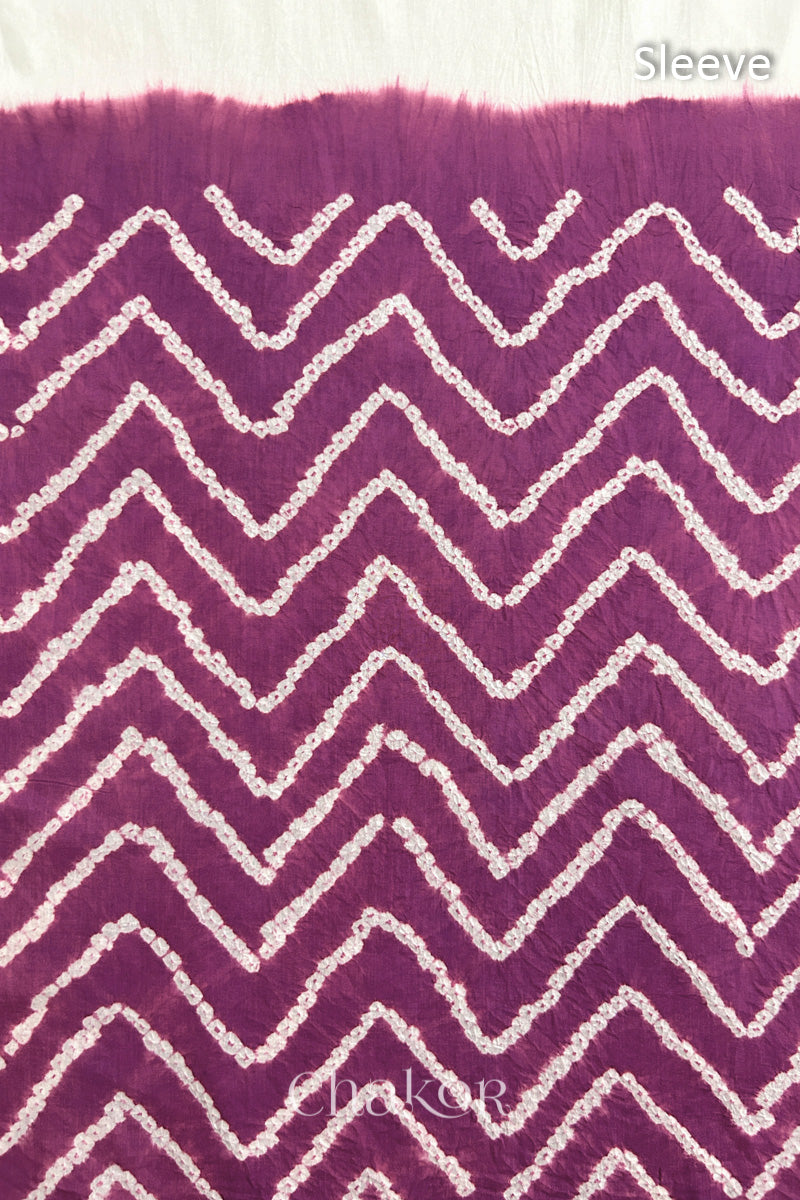 Close-up of deep violet bandhani fabric featuring chevron tie-dye design, with Chakor brand logo. Text reads sleeve detail.