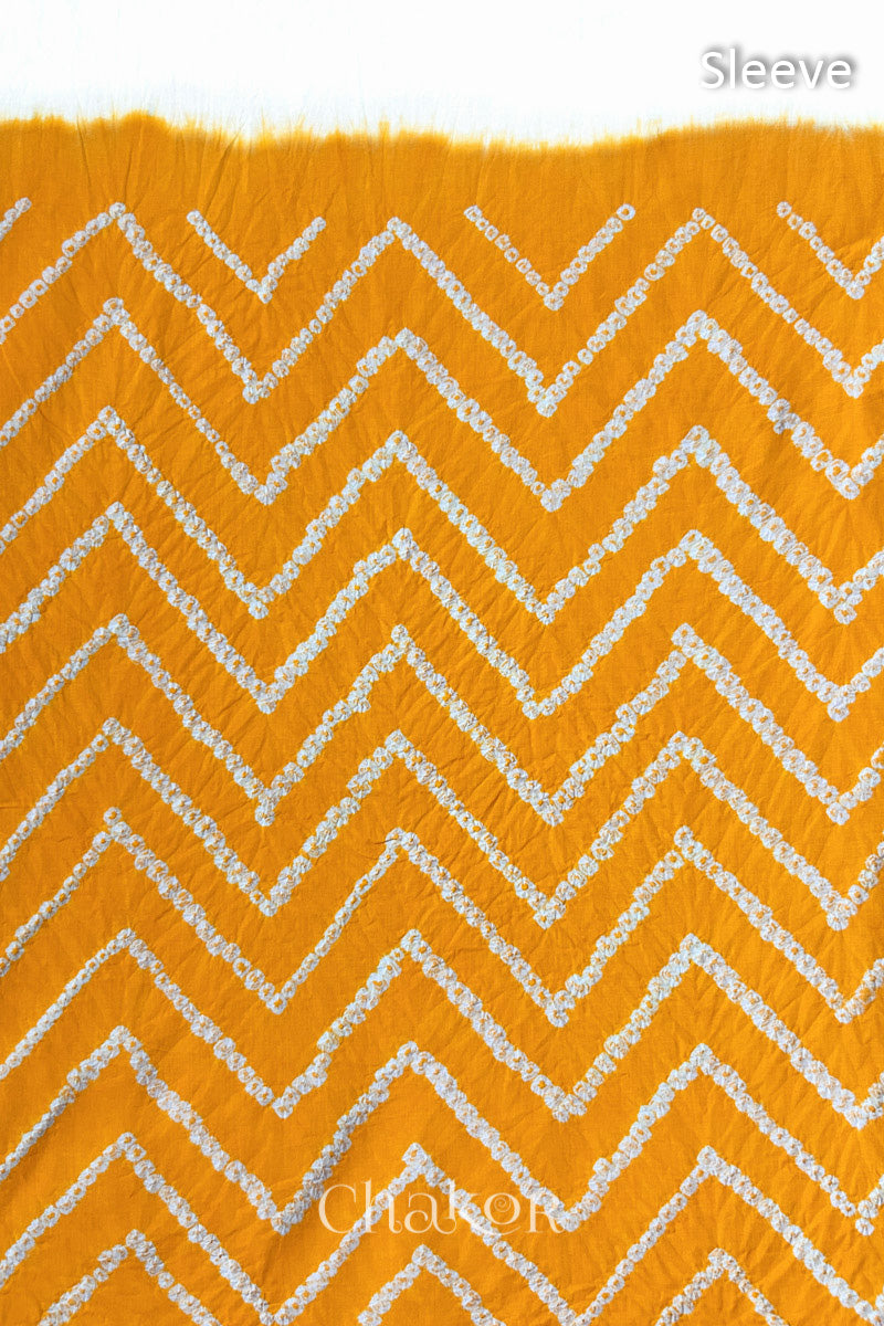 Close-up of bandhani fabric featuring chevron tie-dye design, with Chakor brand logo. Text reads sleeve details.
