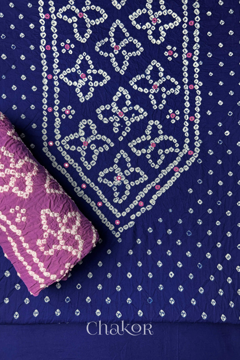 Front yoke detail of Navy Blue Bandhani cotton kurta fabric with hand embroidery and mirror work and Mauve dupatta rolled up.
