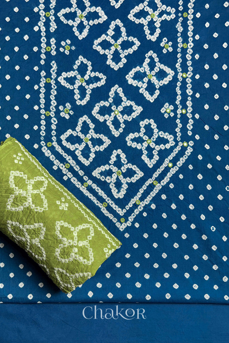 Front yoke detail of Indigo Blue Bandhani cotton kurta fabric with hand embroidery and mirror work and Lime Green dupatta rolled up.
