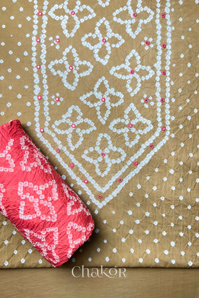 Front yoke detail of Beige Bandhani cotton kurta fabric with hand embroidery and mirror work and Coral pink dupatta rolled up.
