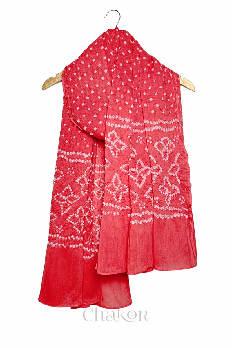 Coral Pink mercerised mulmul cotton dupatta with Bandhani floral pallu design draped on hanger.
